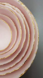 Set of 7 stoneware fine bone china nesting bowls in dusty pink and white with various finishes.