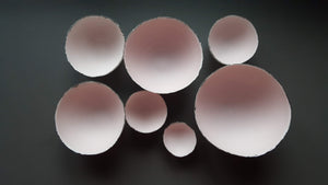 Set of 7 stoneware fine bone china nesting bowls in dusty pink and white with various finishes.