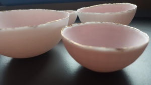 Set of 7 stoneware fine bone china nesting bowls in dusty pink and white with various finishes.