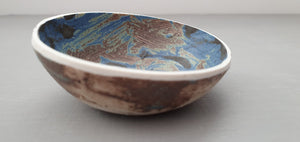 Stoneware small decorative bowl with chocolate, black and blue glaze and textured base.