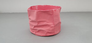 Crumpled paper looking white vessel made out of English fine bone china in pale red / dark pink colour and glazed rims. one off piece