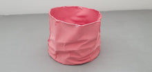 Load image into Gallery viewer, Crumpled paper looking white vessel made out of English fine bone china in pale red / dark pink colour and glazed rims. one off piece