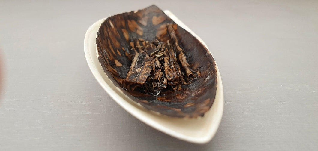 A set of two stoneware fine china vessels with dark glaze and mother of pearl resembles Lilly petals.