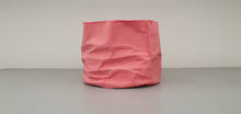 Load image into Gallery viewer, Crumpled paper looking white vessel made out of English fine bone china in pale red / dark pink colour and glazed rims. one off piece