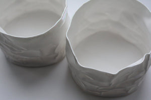 Crumpled paper looking vessel made out of fine bone china with a hint of mother of pearl, iridescent