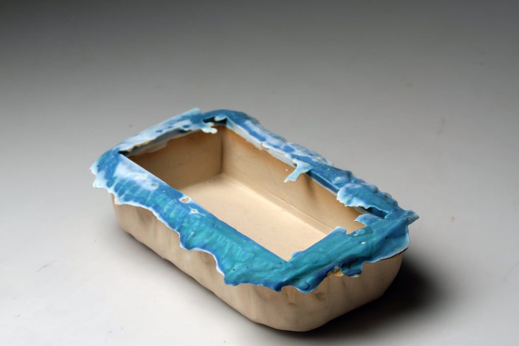 White stoneware clay container with turquoise rim