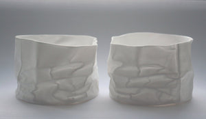 Crumpled paper looking vessel made out of fine bone china with a hint of mother of pearl, iridescent