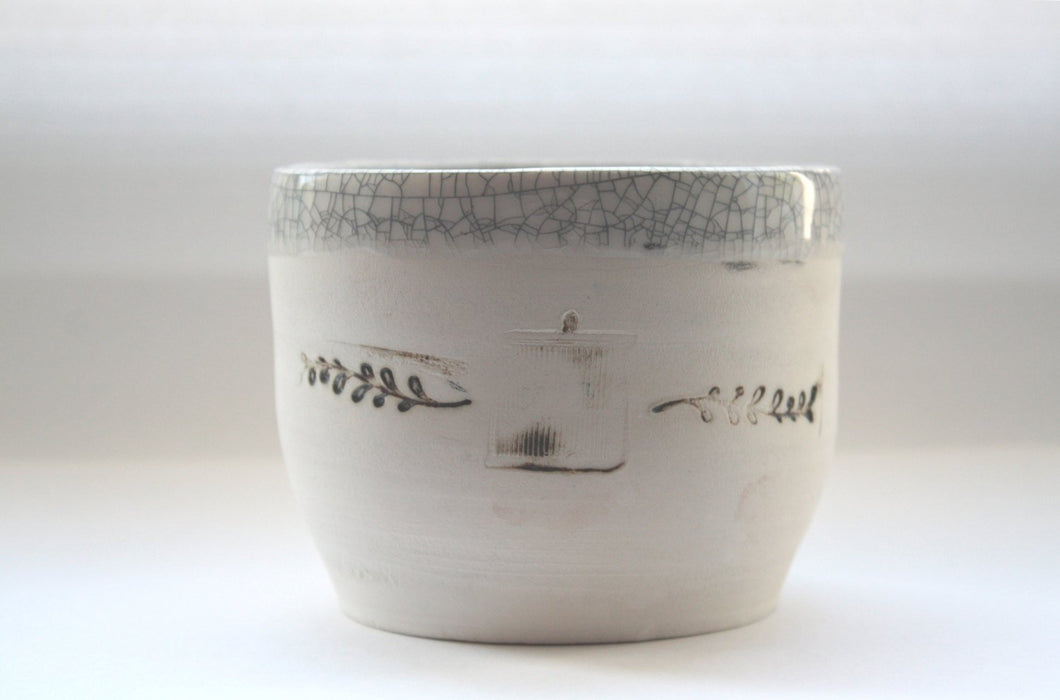 Earthenware vessel handthrown with an aged look and embossed branches and bird cage