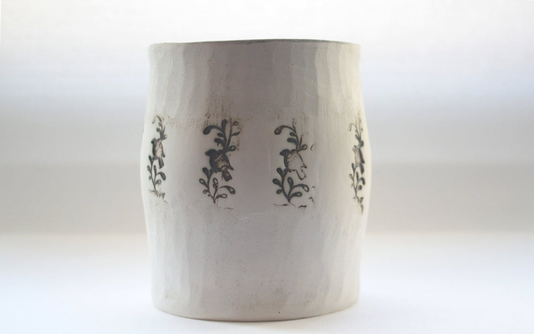 Earthenware vessel handthrown with an aged look and embossed birds on branches