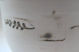 Earthenware vessel handthrown with an aged look and embossed branches and bird cage