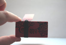 Load image into Gallery viewer, Red gift box matchbox style with black floral pattern and ribbon